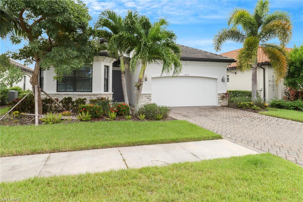 1878 Mustique Street Naples, FL 34120 - Photo 3 of 50 a front view of a house with a garden and trees