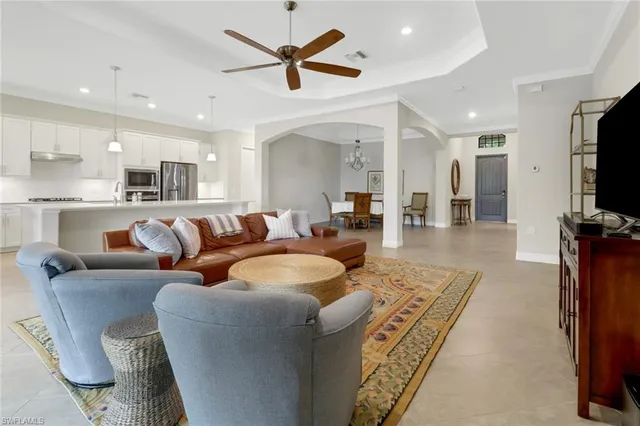 a living room with furniture a flat screen tv and kitchen view