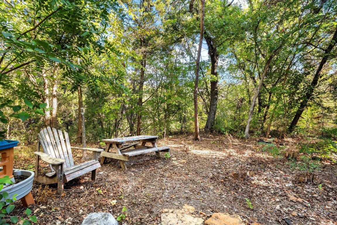 3913 Caney Creek Road Austin, TX 78732 - Photo 26 of 30 a view of a wooden bench and trees in the back yard