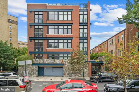 a front view of a building with cars parked