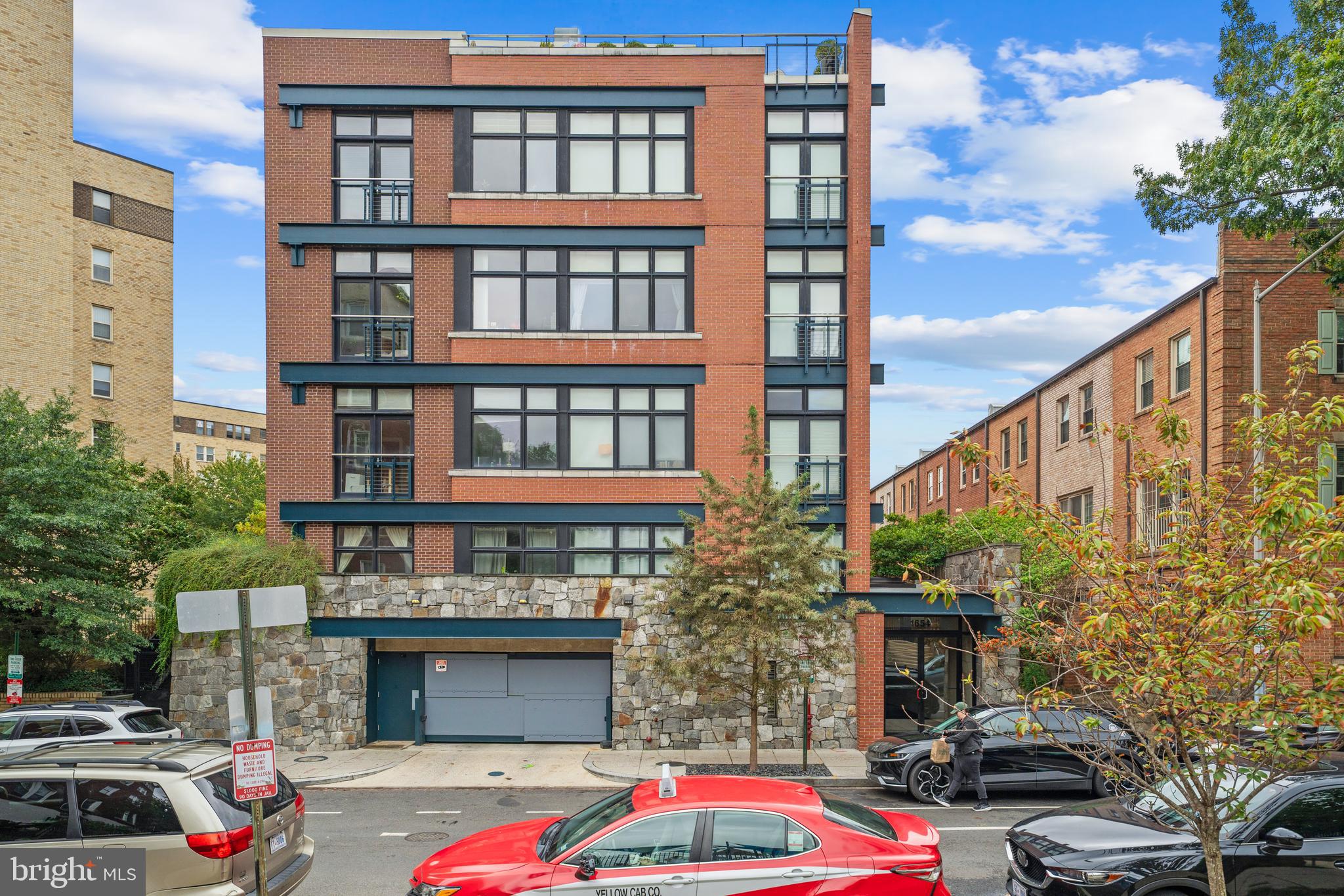 a front view of a building with cars parked