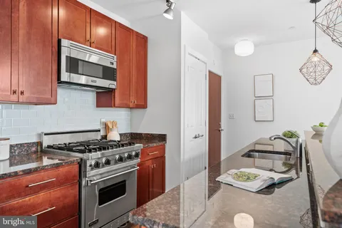 a kitchen with stainless steel appliances granite countertop a stove and a microwave