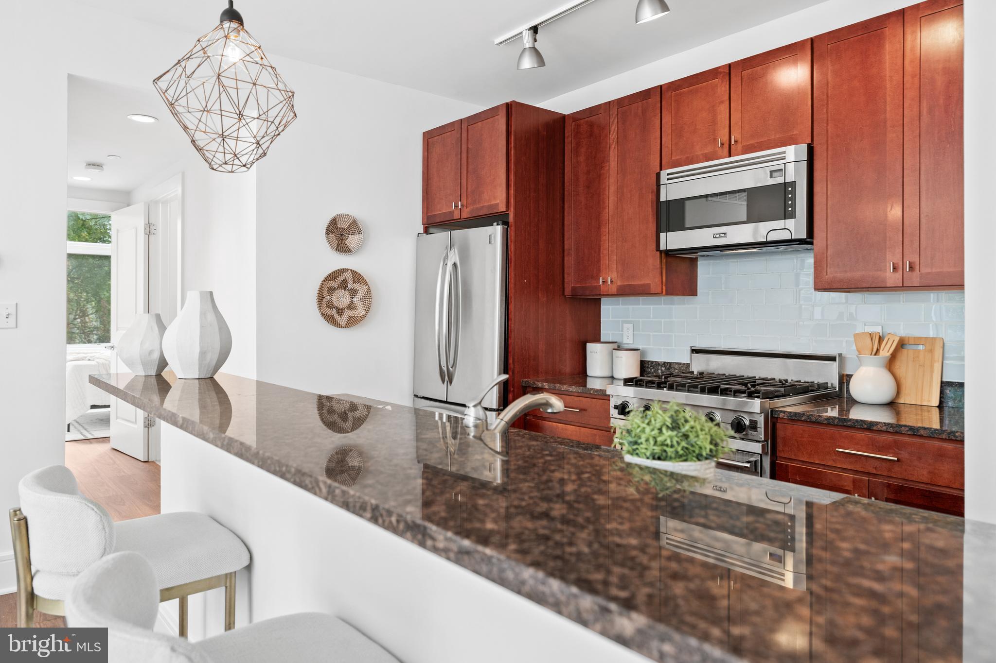 1654 Euclid Street Northwest, Unit 204 Washington, DC 20009 - Photo 4 of 20 a kitchen with a sink and a stove top oven with wooden floor