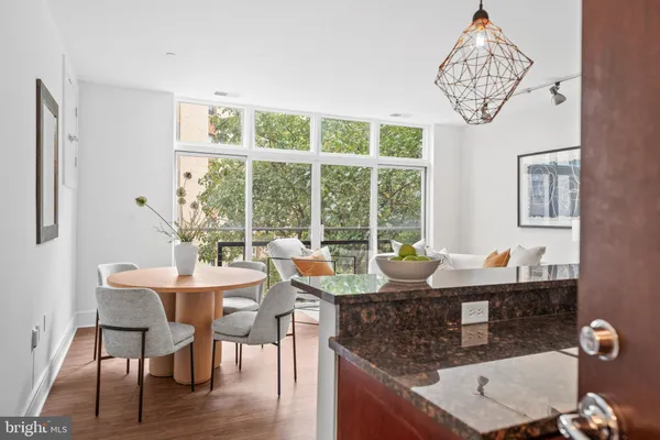 a dining room with furniture a chandelier and wooden floor