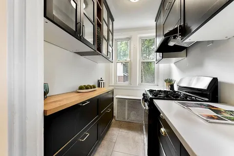a kitchen with stainless steel appliances granite countertop a refrigerator a stove a sink and a dining table with chairs