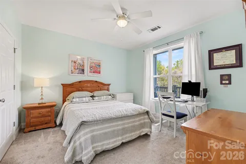 a bedroom with a bed a couch and a window
