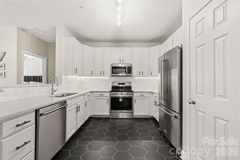 a kitchen with stainless steel appliances granite countertop a refrigerator sink and stove