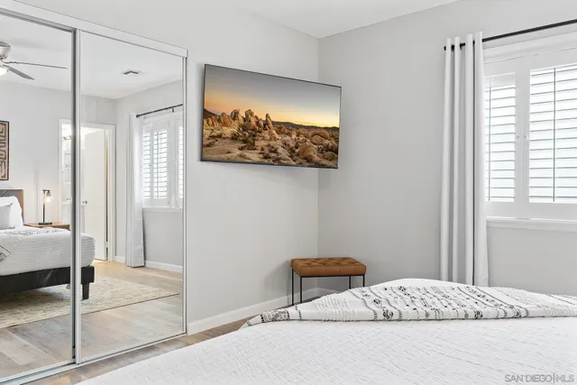 a bedroom with a bed and a painting on the wall