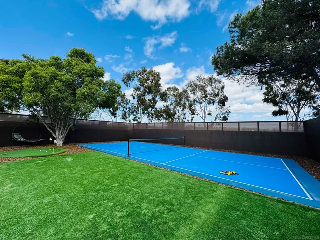 a view of a backyard with a house and wooden fence