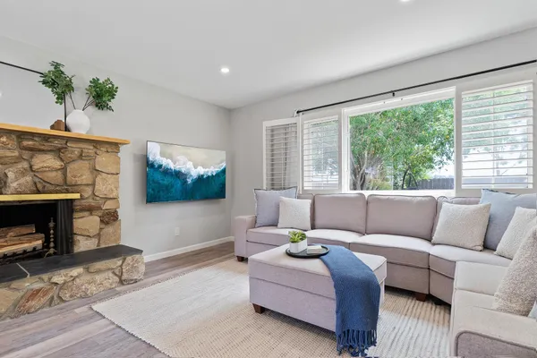 a living room with furniture a large window and a fireplace