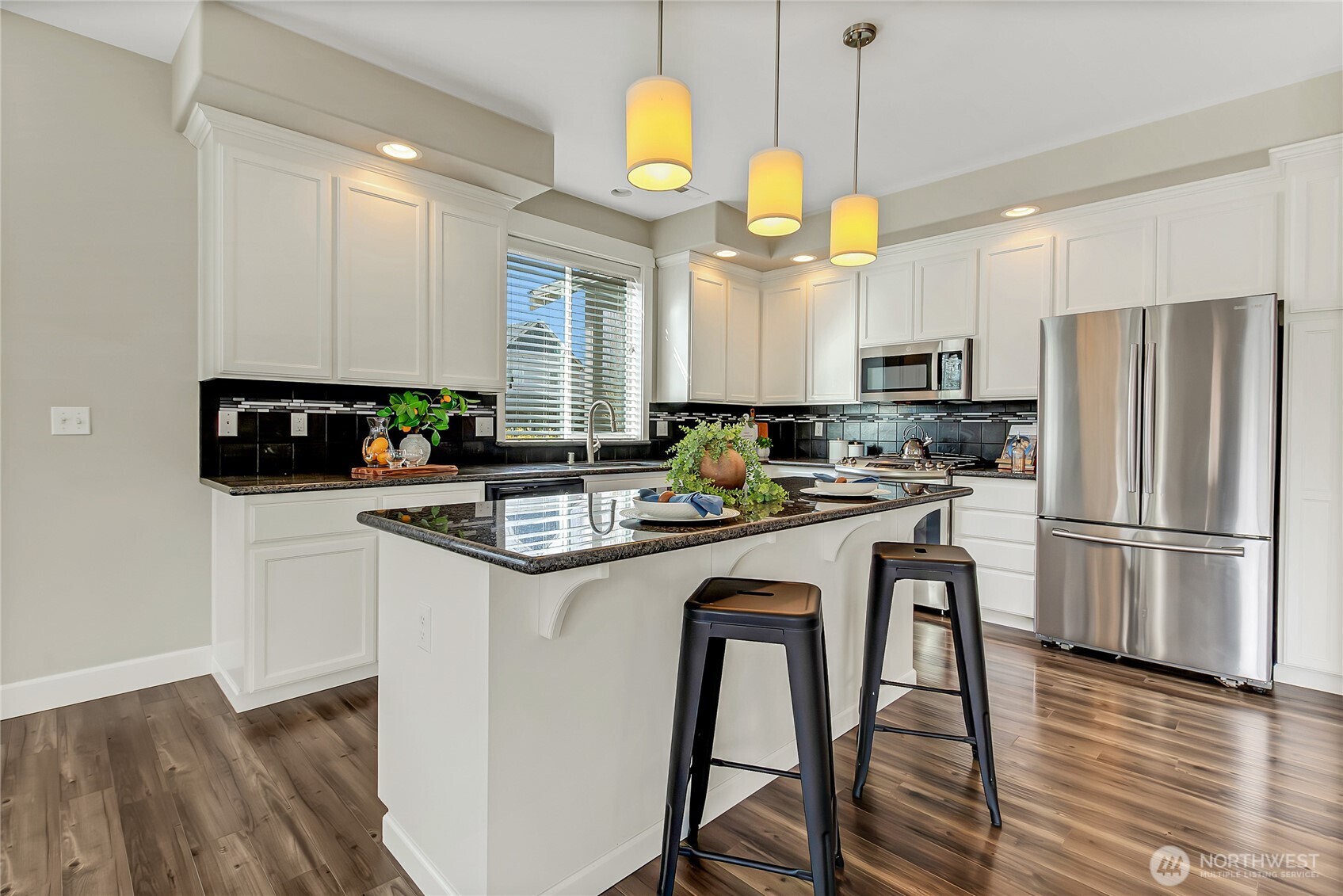 14925 Benton Loop Sumner, WA 98390 - Photo 8 of 40 a kitchen with stainless steel appliances granite countertop a sink a stove a refrigerator and island with wooden floor