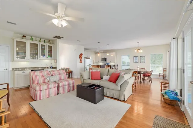 a dining room with furniture a chandelier and wooden floor
