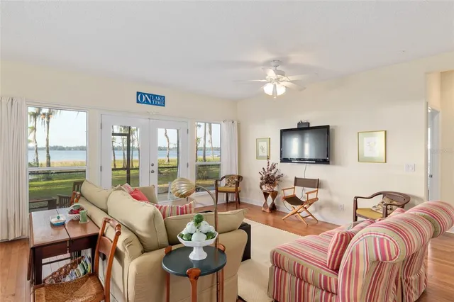 a view of a dining room and livingroom with furniture wooden floor a chandelier