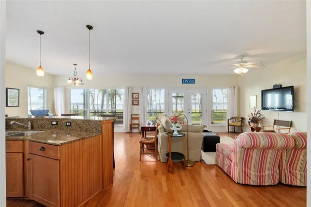 a living room with furniture kitchen view and a large window