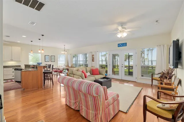 a living room with furniture kitchen view and a large window