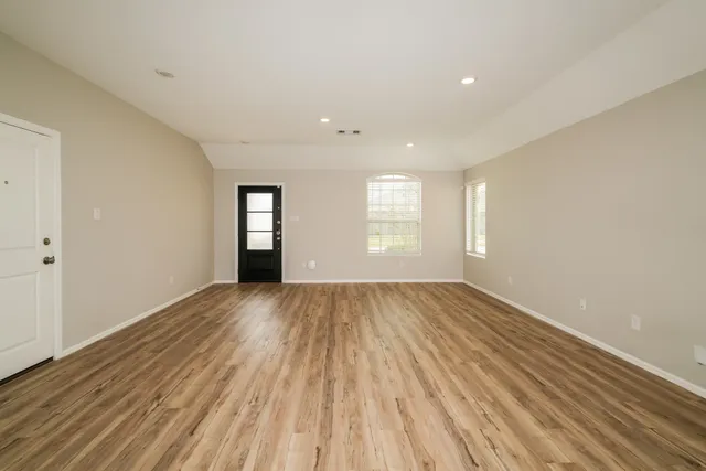 wooden floor in an empty room with a window