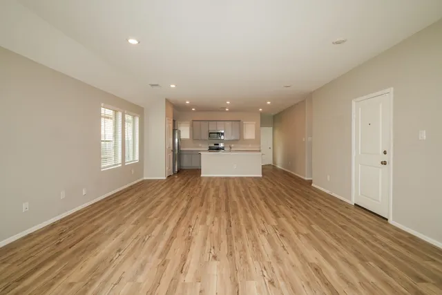 a view of empty room with wooden floor and window
