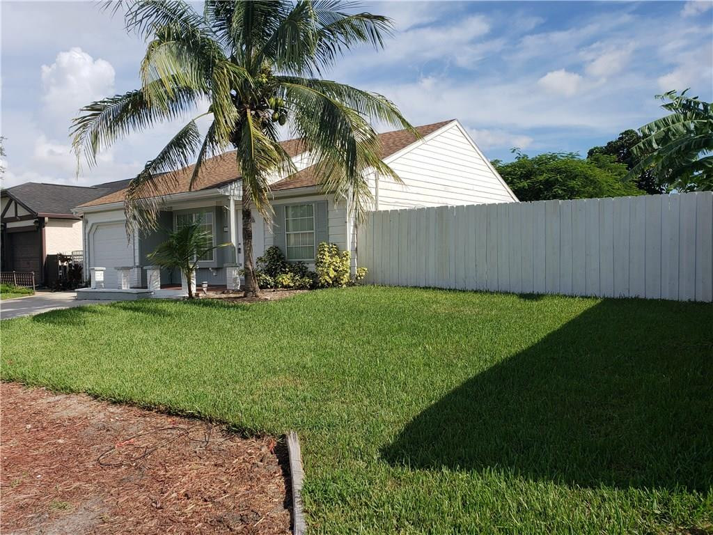11100 North Terradas Lane Boca Raton, FL 33428 - Photo 20 of 22 a front view of a house with a garden and trees