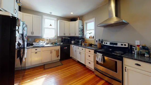 a kitchen with granite countertop stainless steel appliances a stove microwave and cabinets