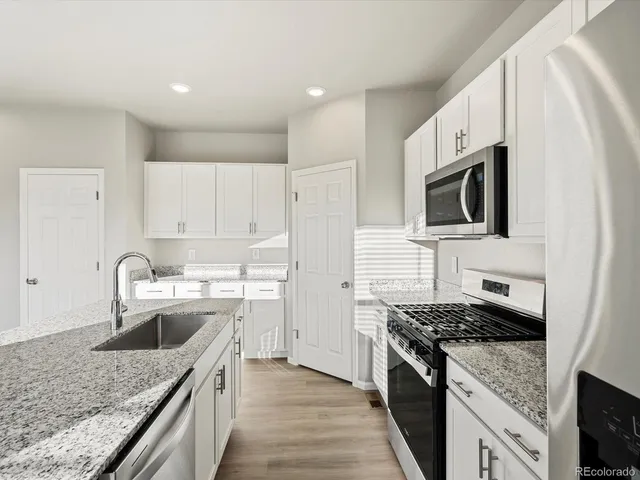 a kitchen with a sink stove top oven and refrigerator