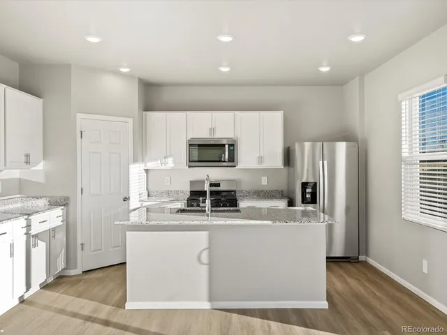 a kitchen with stainless steel appliances a refrigerator sink and microwave