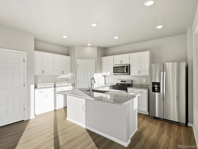 a kitchen with refrigerator cabinets and wooden floor