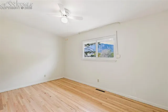 an empty room with a window and a ceiling fan