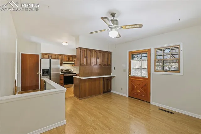 a view of a kitchen with furniture a ceiling fan and windows