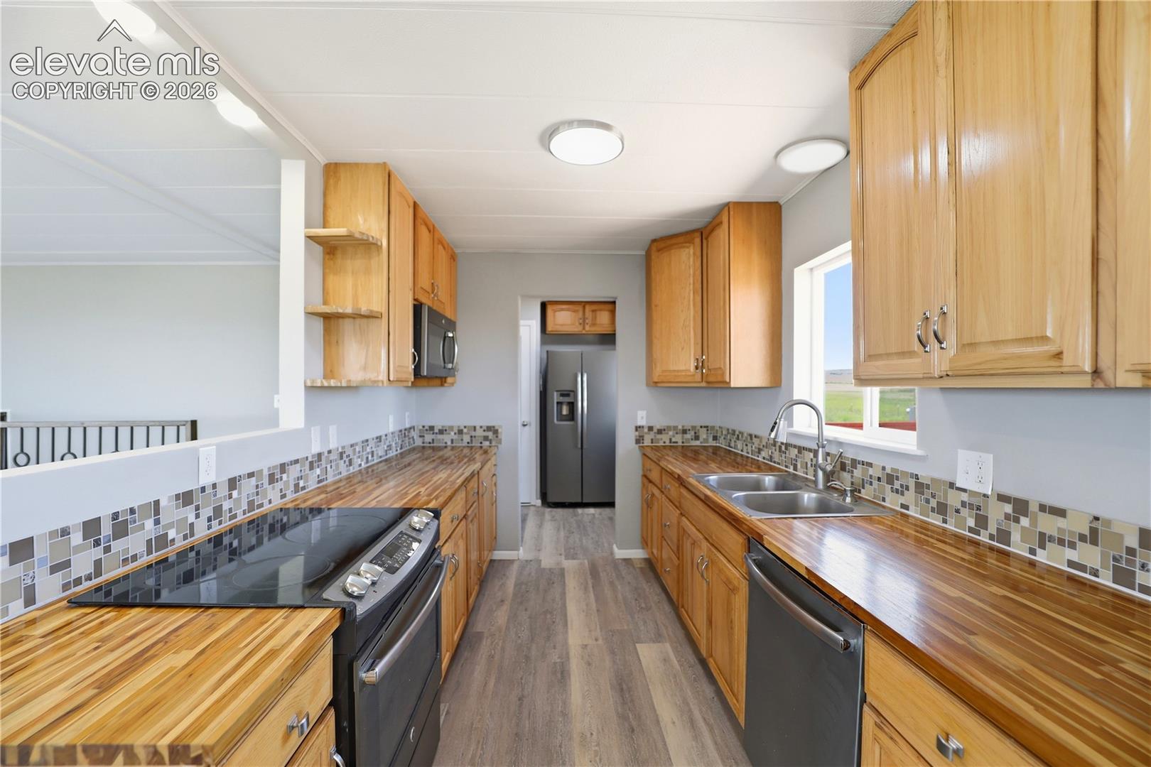 19027 Murphy Road Peyton, CO 80831 - Photo 8 of 49 Butcher Block, Open Concept, Vinyl Plank, Mud Space Through Kitchen, Dining Room Sliding Door Off Kitchen