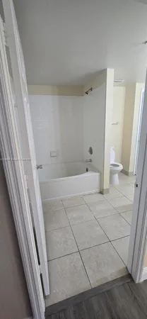 a kitchen with a sink a refrigerator and cabinets