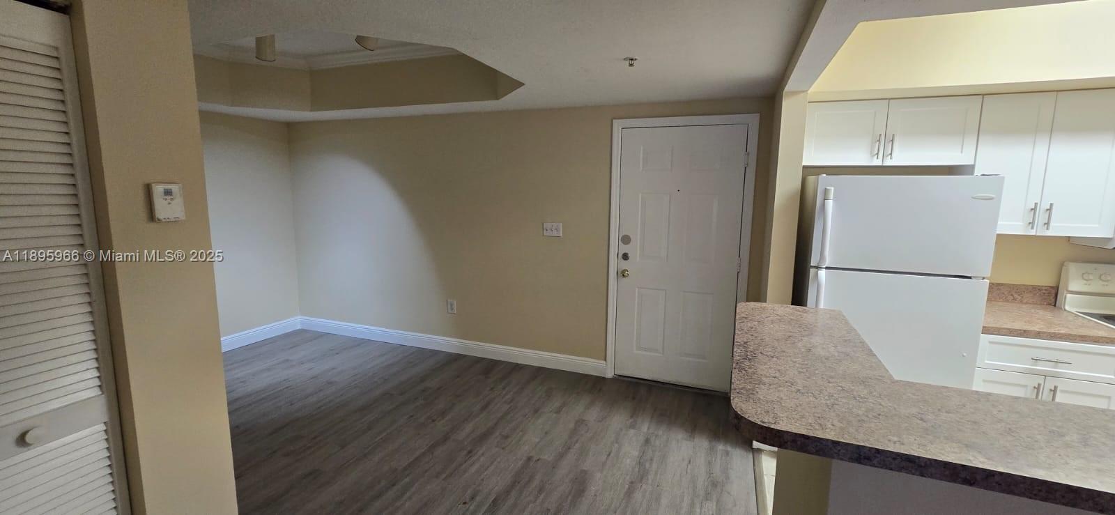 230 Southwest 117th Terrace, Unit 11208 Pembroke Pines, FL 33025 - Photo 22 of 28 a view of kitchen with cabinets and wooden floor