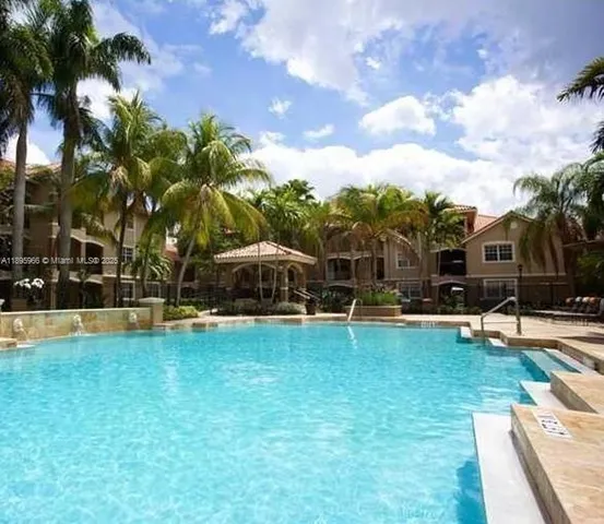 a view of a swimming pool with lawn chairs and a big yard