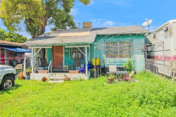 a view of a house with a yard patio and furniture