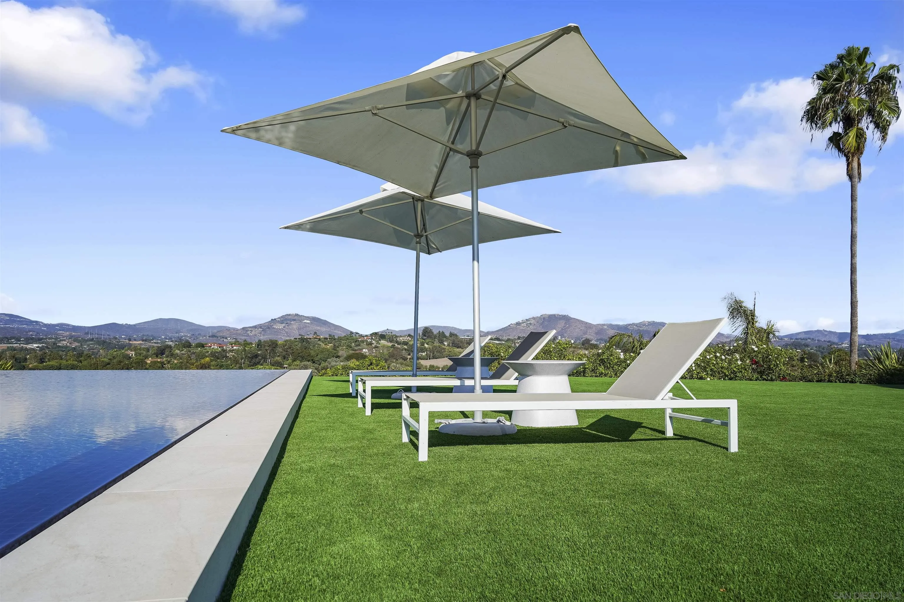 5516 La Crescenta Road Rancho Santa Fe, CA 92067 - Photo 29 of 49 a view of a lake with a table and chairs under an umbrella