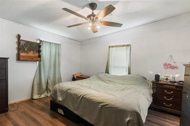 a bedroom with a bed and a ceiling fan