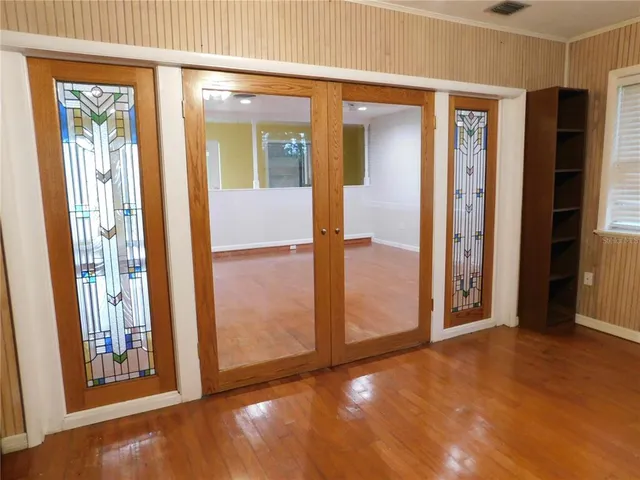 an empty room with wooden floor fireplace and windows