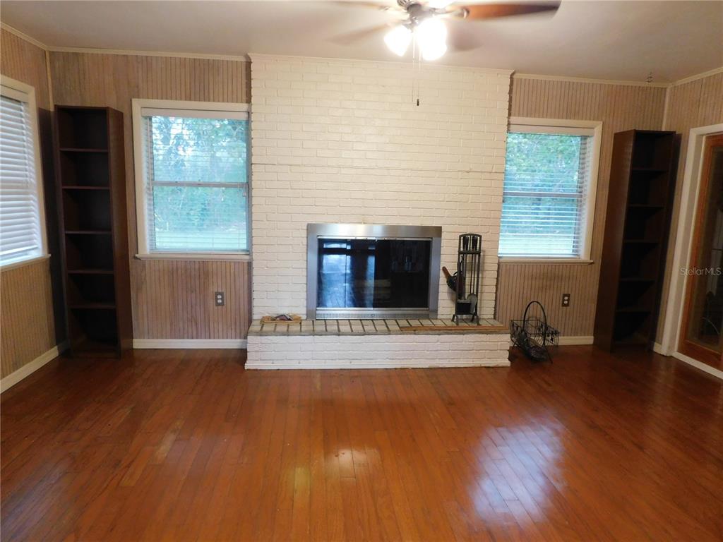 888 Forest Glen Road Clearwater, FL 33765 - Photo 16 of 61 a view of empty room with wooden floor and fireplace