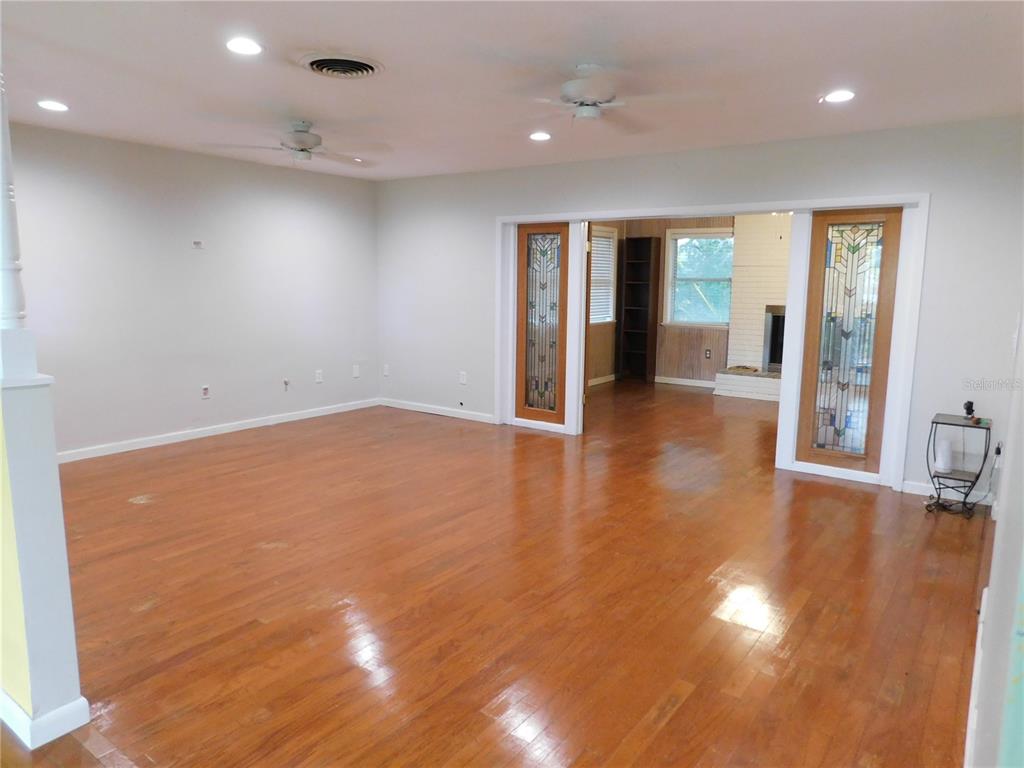 888 Forest Glen Road Clearwater, FL 33765 - Photo 3 of 61 an empty room with wooden floor and windows