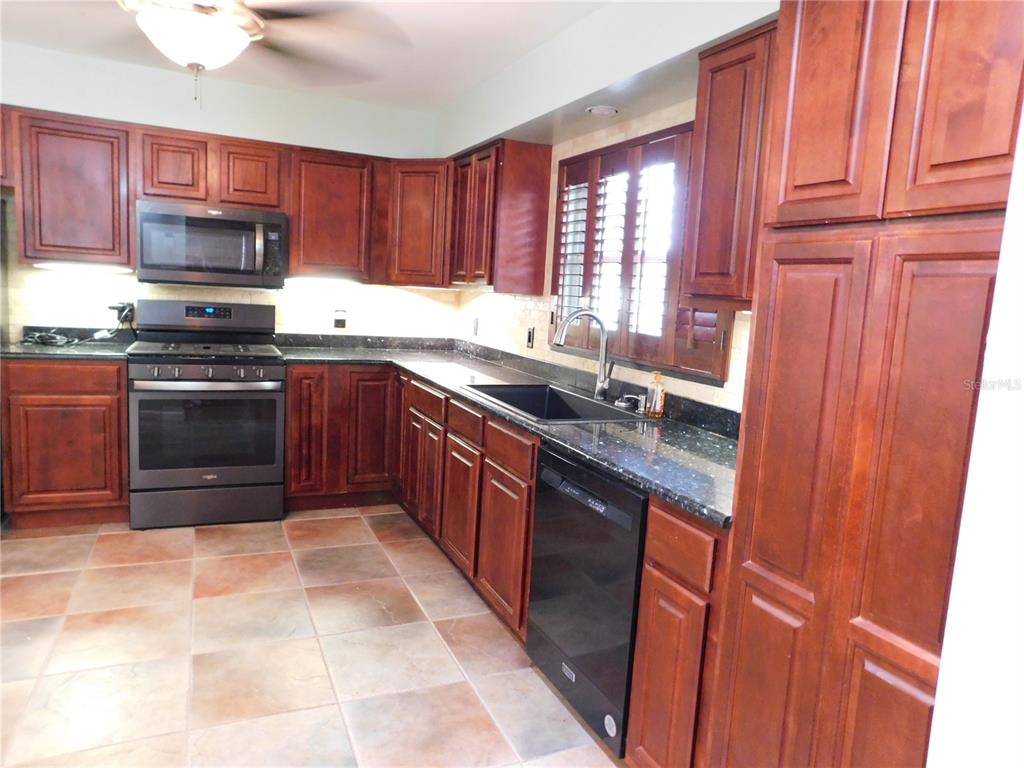 888 Forest Glen Road Clearwater, FL 33765 - Photo 7 of 61 a kitchen with stainless steel appliances granite countertop a stove sink and microwave