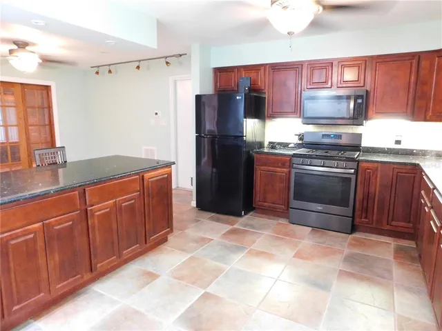 a kitchen with stainless steel appliances granite countertop a refrigerator and a sink
