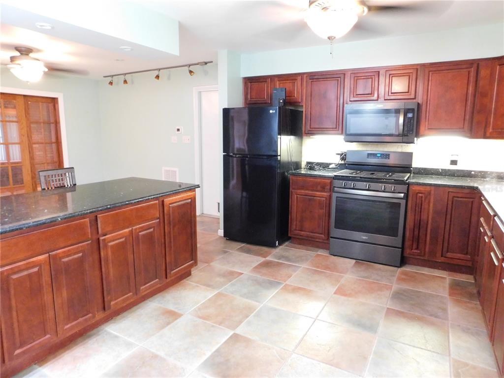 888 Forest Glen Road Clearwater, FL 33765 - Photo 8 of 61 a kitchen with stainless steel appliances granite countertop a stove refrigerator and microwave