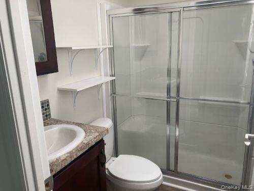 1661 Old Country Road, Unit 49 Riverhead, NY 11901 - Photo 10 of 11 a bathroom with a sink a toilet and shower