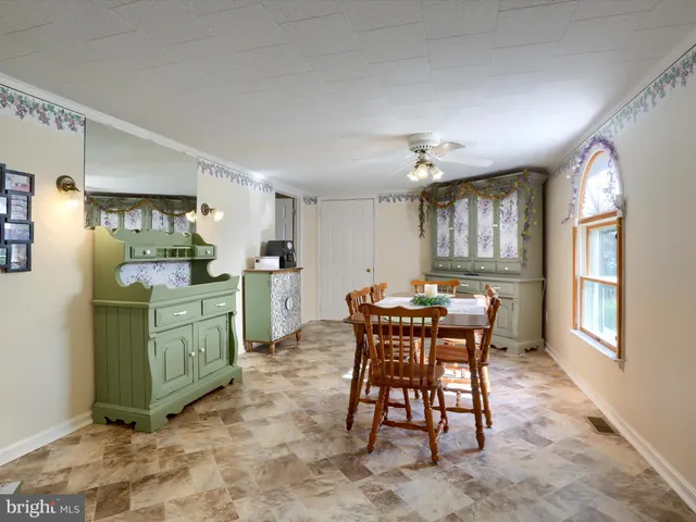 a kitchen with a dining table chairs and cabinets