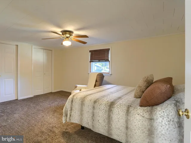 a bedroom with a bed and a ceiling fan
