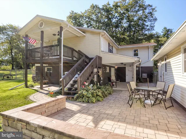 a view of a house with backyard and sitting area
