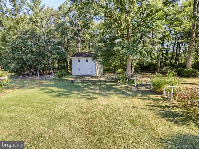 a view of a pool with lawn chairs under an umbrella