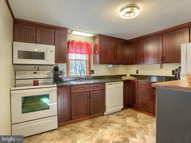 a kitchen with stainless steel appliances granite countertop a stove microwave and cabinets