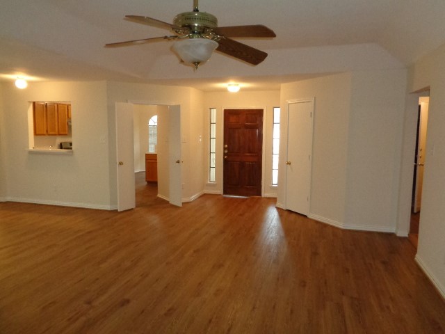 17823 Poppy Trails Lane Houston, TX 77084 - Photo 7 of 22 a view of an empty room with wooden floor and a ceiling fan