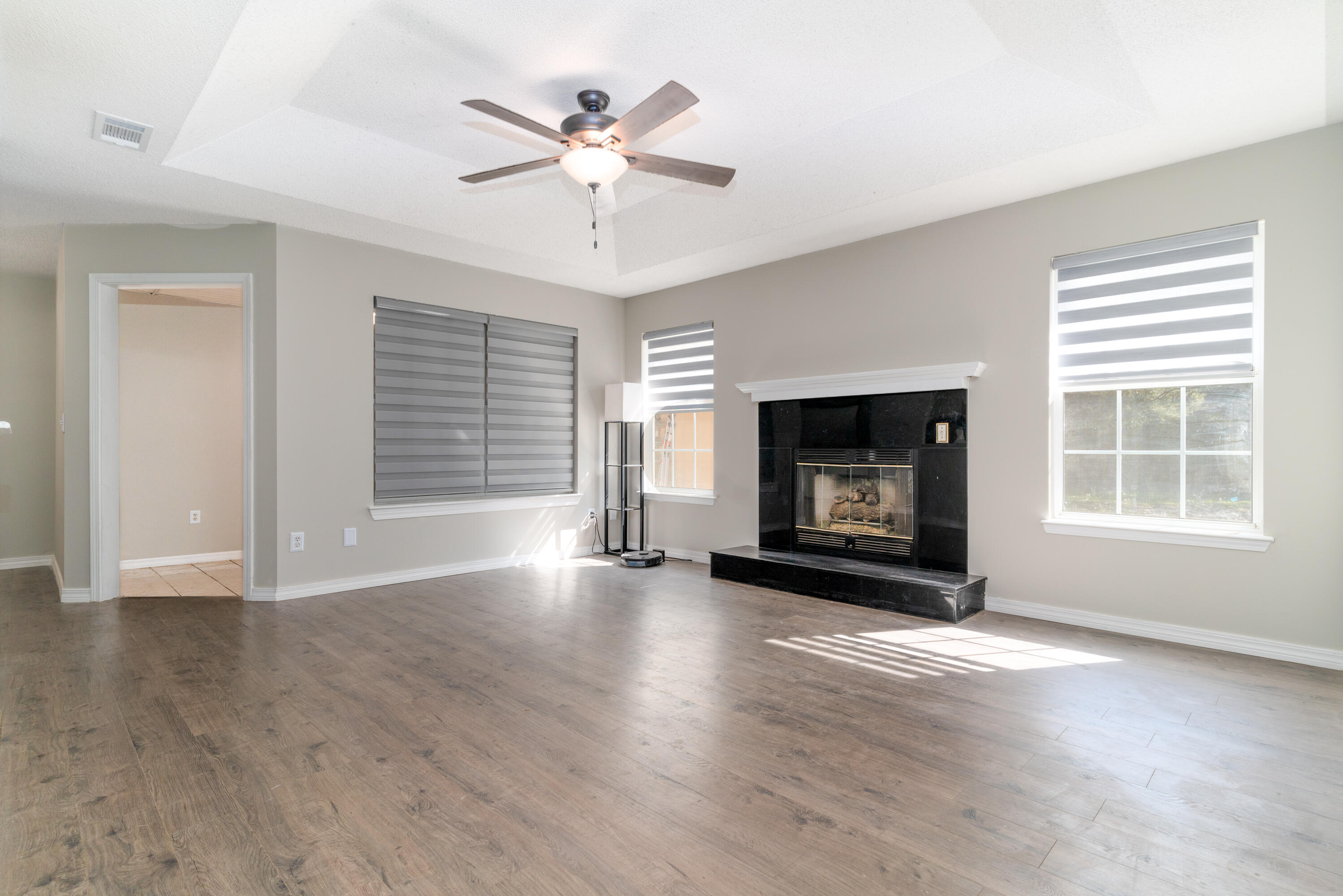1530 Heritage Road Fort Walton Beach, FL 32547 - Photo 16 of 37 a view of an empty room with wooden floor fireplace and a window