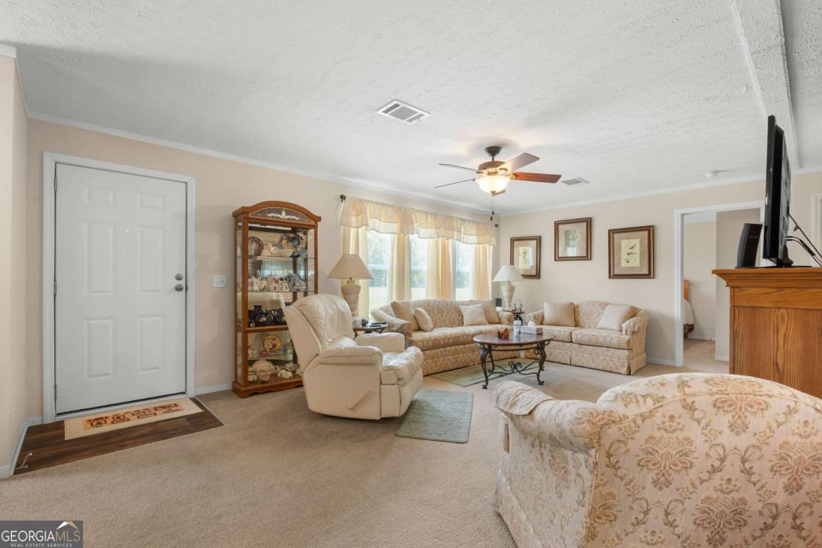 3516 Bennetts Landing Road Millen, GA 30442 - Photo 7 of 34 a living room with furniture and a chandelier